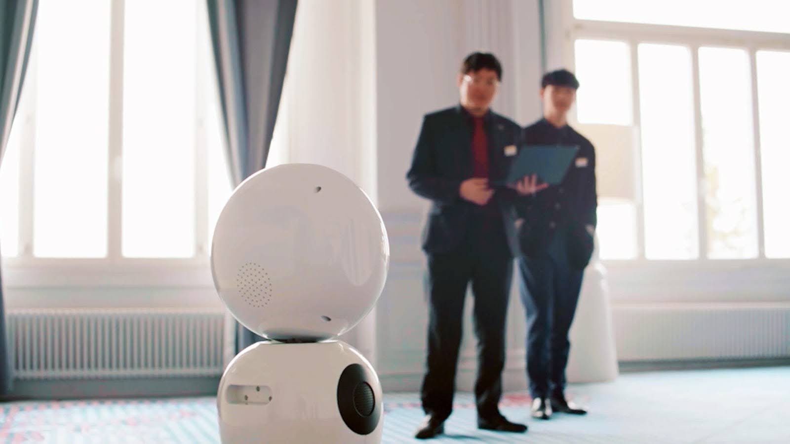 Two hospitality managers looking at a robot