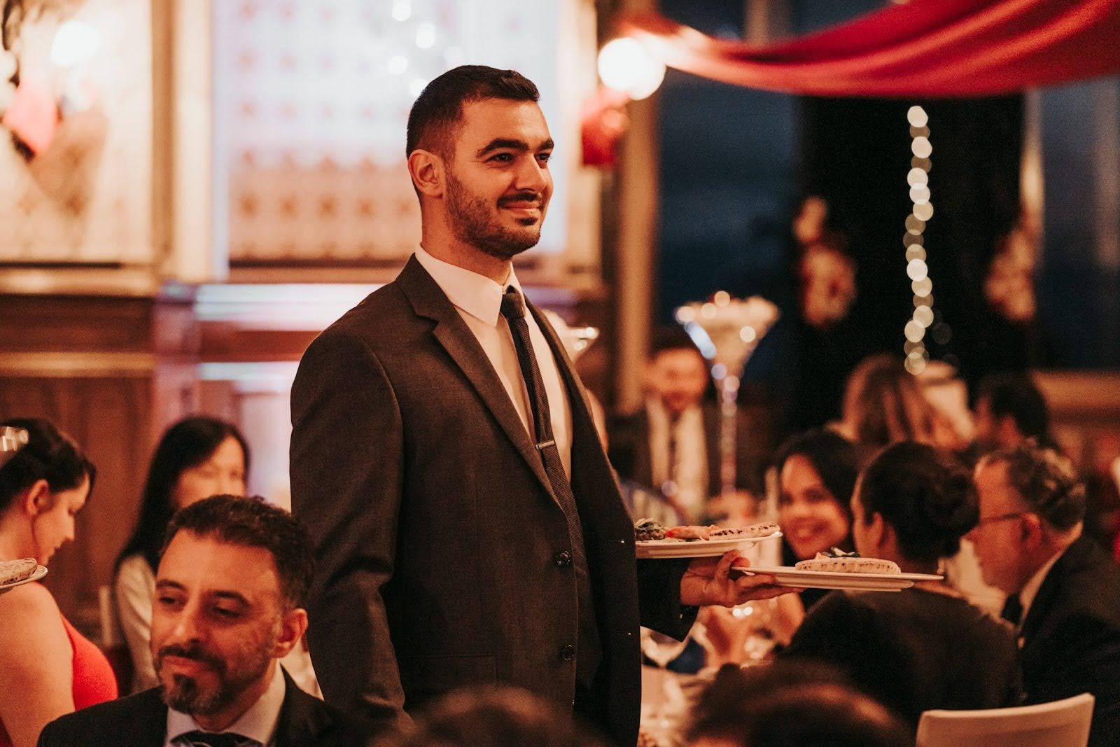 A person stood up and smiling in a restaurant