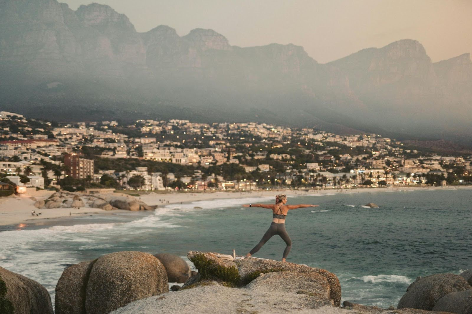 A woman doing yoga on the top of a mountain